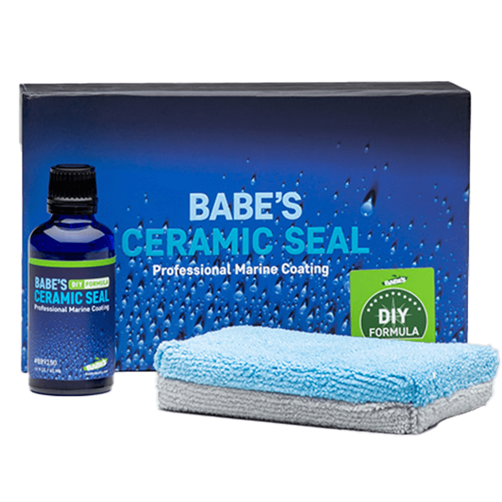 A blue bottle of BABE'S Ceramic Seal – DIY Formula by BABE'S Boat Care sits next to a blue and gray microfiber cloth and a product box featuring water droplet graphics and “Professional Marine Coating.”.