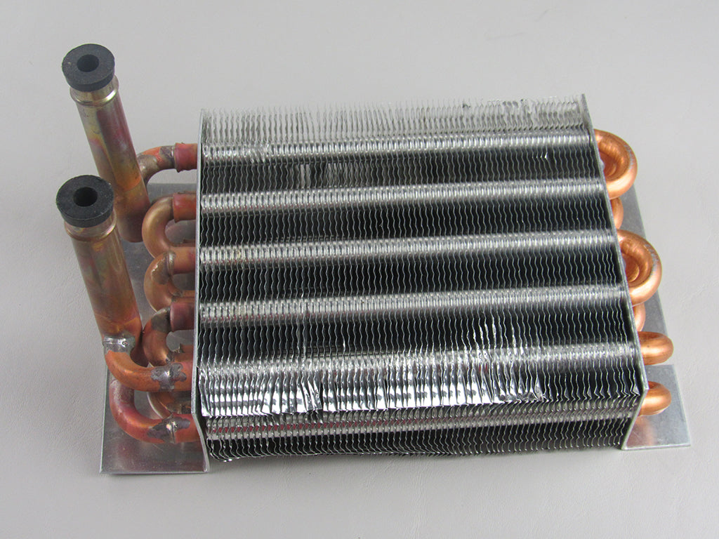 The Malibu Heater Core (006677) for Maradyne 2-vent models features copper pipes and thin aluminum fins, serving as an OEM replacement. It is shown on a light gray surface.