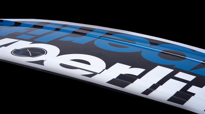 Close-up of the Hyperlite 2025 Motive Jr. Wakeboard with Remix Bindings featuring bold black and blue text on a white background, ideal for beginner to intermediate riders, set against a black backdrop.
