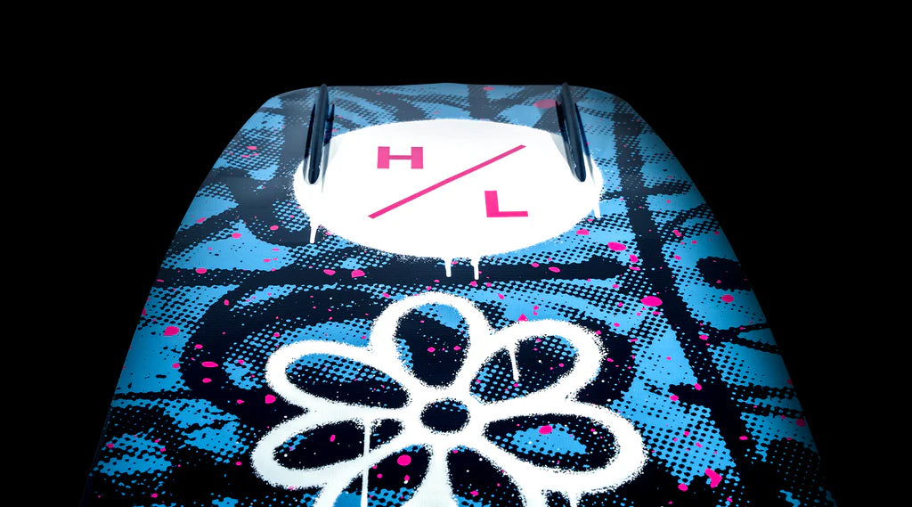 Close-up of the Hyperlite 2025 Journey Wakeboard showcasing a vibrant blue, black, and pink graffiti design with a flower and the H/L symbol on a black background—an ideal choice for enthusiasts embracing the thrill of wakeboarding.