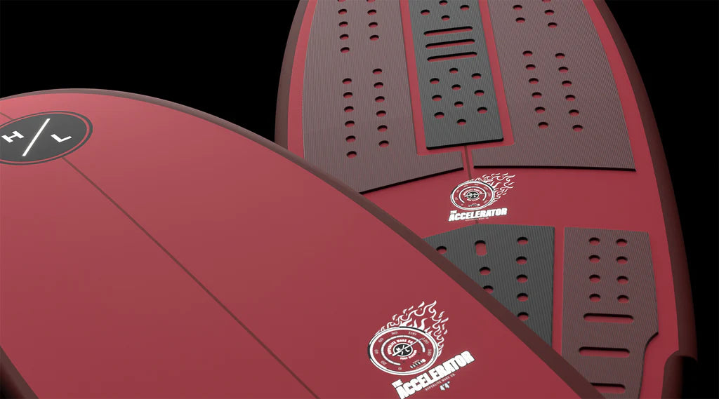 Close-up of two red Hyperlite Accelerator Wakesurf Boards 2026 with black traction pads, white flame logos, and H/L branding; one displays detailed grip patterns on the deck.