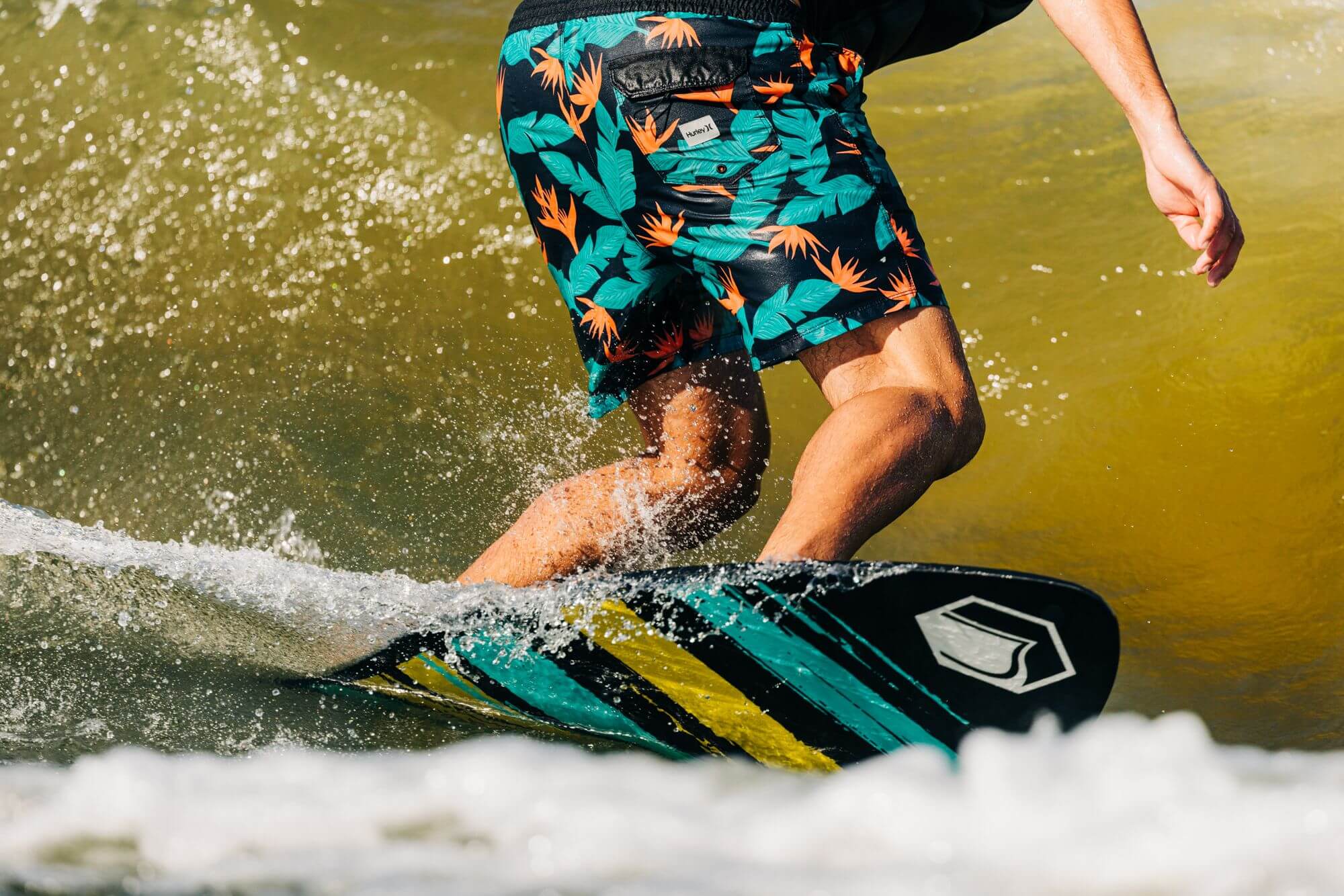 A man riding a surfboard on a wave, showcasing the incredible performance of Liquid Force 2024 Reign Pro Wakesurf Board (Pre-Order) made with Full Carbon Layup technology.