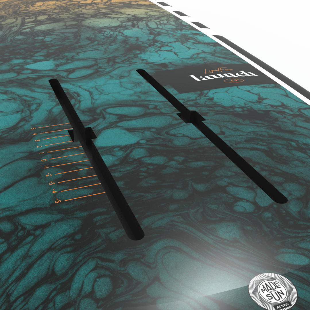 Close-up of a green and black marbled Liquid Force 2025 Launch Foil Board with adjustable truck slots and the word "Land" partially visible.