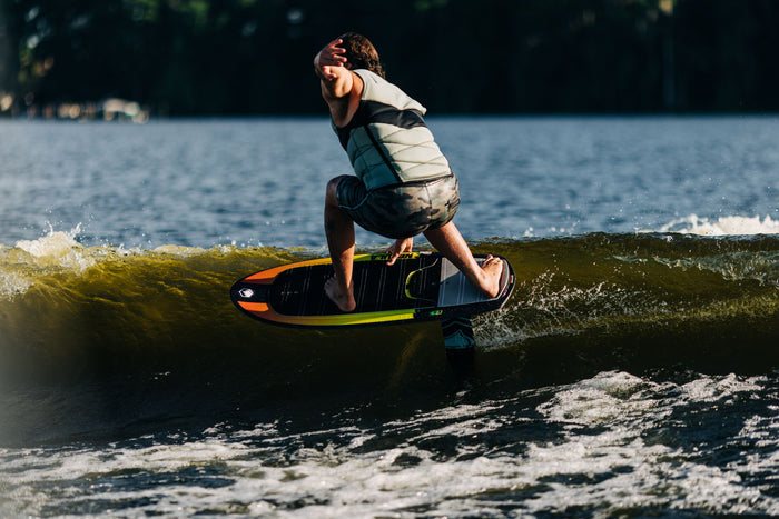 A man riding a wave on a surfboard, showcasing the impressive performance of the Liquid Force 2024 Nebula | Horizon Surf 155 Foil Package by Liquid Force.