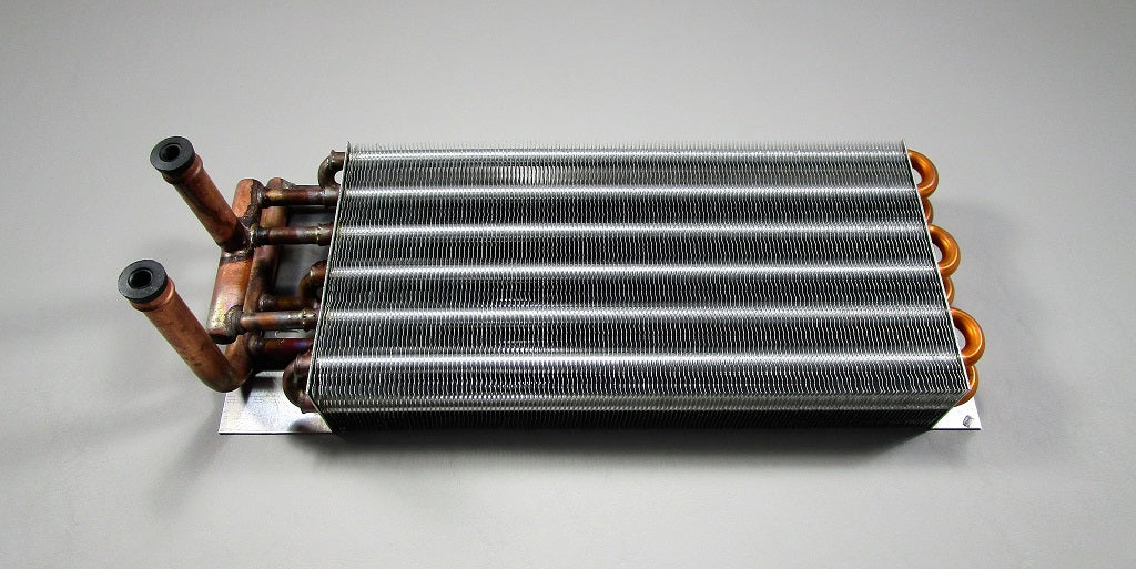 The Malibu 3 Outlet Heater Core (Maradyne Models Only, 006678) features copper pipes and metal fins, designed for heating or cooling in three vent HVAC units. Shown here on a light gray surface. Brand: Malibu.