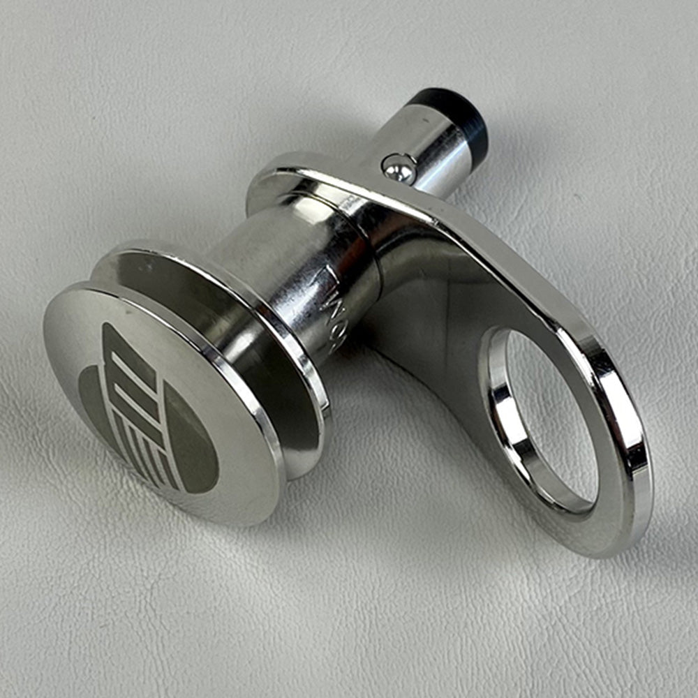 The Malibu Cleat Phender Pro Quick Release 1/2" Pin by Malibu, featuring a cylindrical metal body, flat engraved end, and tab with a large round hole, rests on a light gray surface.
