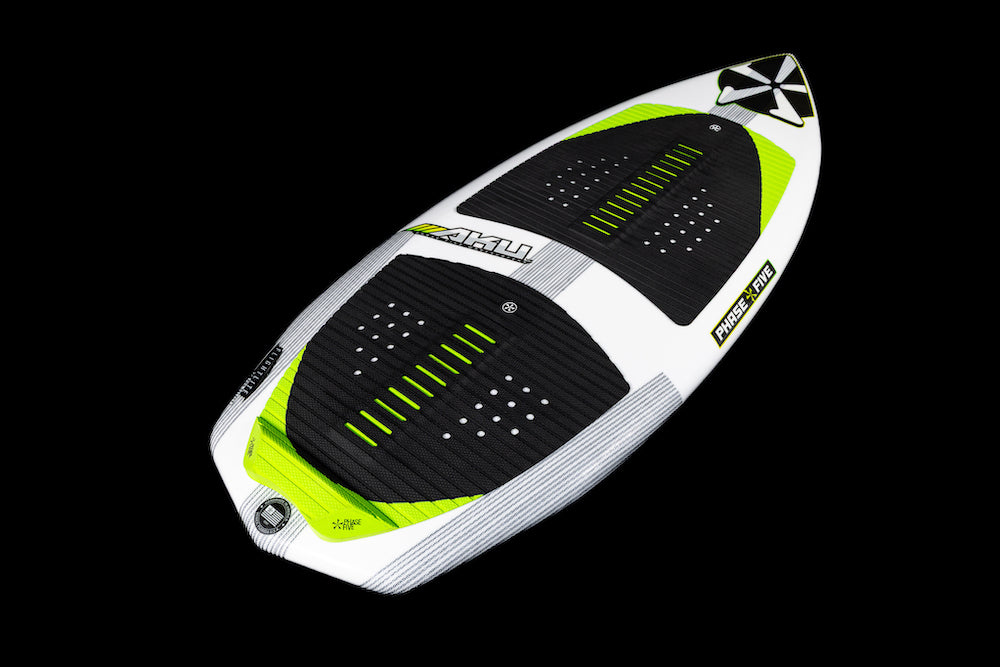 The Phase 5 Aku v2 Wakesurf Board 2026 features a white and green design, black textured grip pads, and a geometric nose pattern, displayed on a black background.