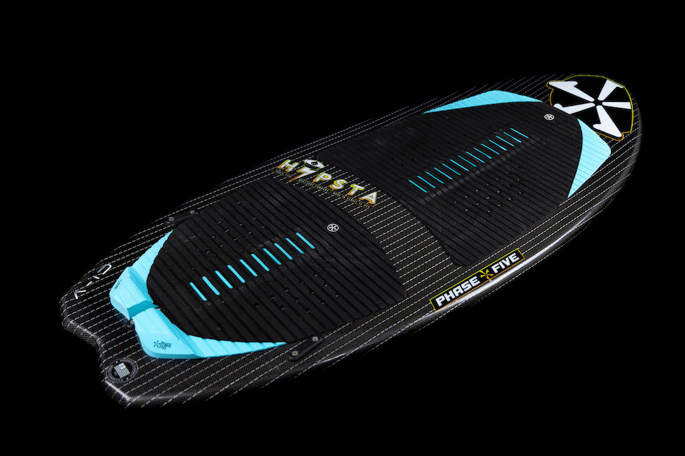 The Phase 5 Hypsta v2 Wakesurf Board 2026 in black and blue, with textured grip pads, striped pattern, TRI-Fin setup, and "Phase 5" branding is displayed on a solid black background.