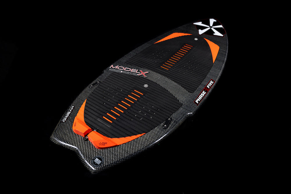 The Phase 5 Model X Wakesurf Board 2026, in black and orange with a carbon fiber texture and white tail design, features GatorSkin glass, textured grip pads, and PHASE FIVE branding. Displayed on a black background.