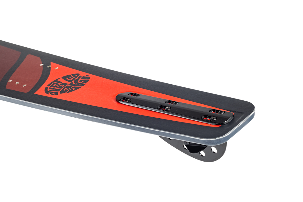 Close-up of the tail section of a snowboard with a red and black design, featuring a metal attachment plate and mounting holes—evoking high-performance gear like the Radar Session Waterski | Prime + ARTP 2026 by Radar.
