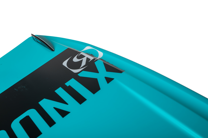 Close-up view of a turquoise boat's bow featuring a black Ronix label and a small accessory, reminiscent of the dynamic design seen in the 2025 District Wakeboard by Ronix, known for explosive jumps.