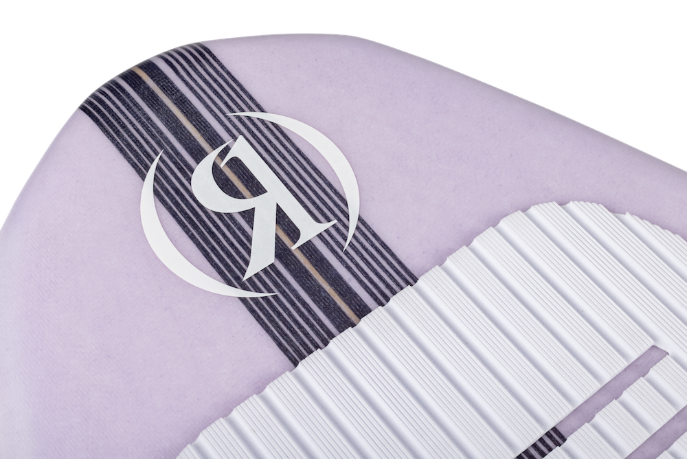 Close-up of the Ronix Women's Aura Flyweight Skimmer 2026: a light purple surfboard with a white R logo in a circle, black and tan stripes, a textured white traction pad, and lightweight flyweight construction for advanced performance.