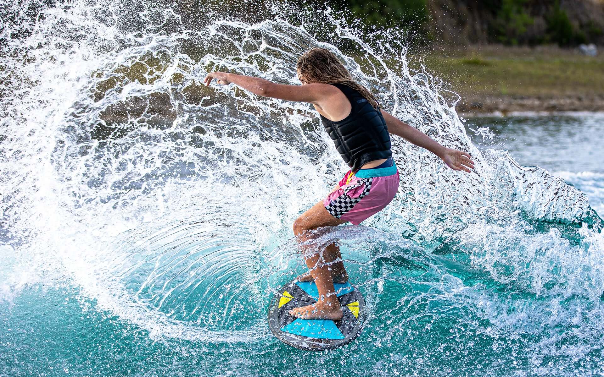 Phase 5 Jett Shreds Key is seen gracefully riding a wave on a surfboard equipped with a Single Fin Setup. The surfer's skillful maneuvers are made possible by the reliable and durable Phase 5 2024 Key Jett Shreds Wakesurf Board.