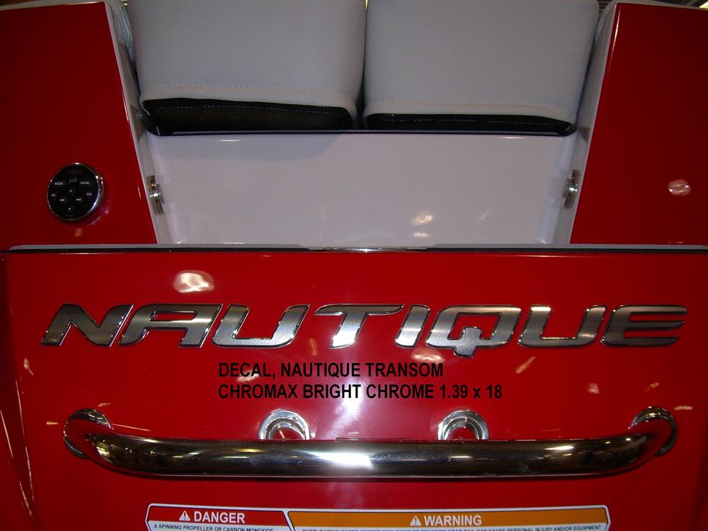 Close-up of a red boat’s transom featuring the Nautique DECAL SUPER AIR NAUTIQUE CHROMAX BLACK CHROME 2.55 x 69 (140016), with partial warning labels visible below.