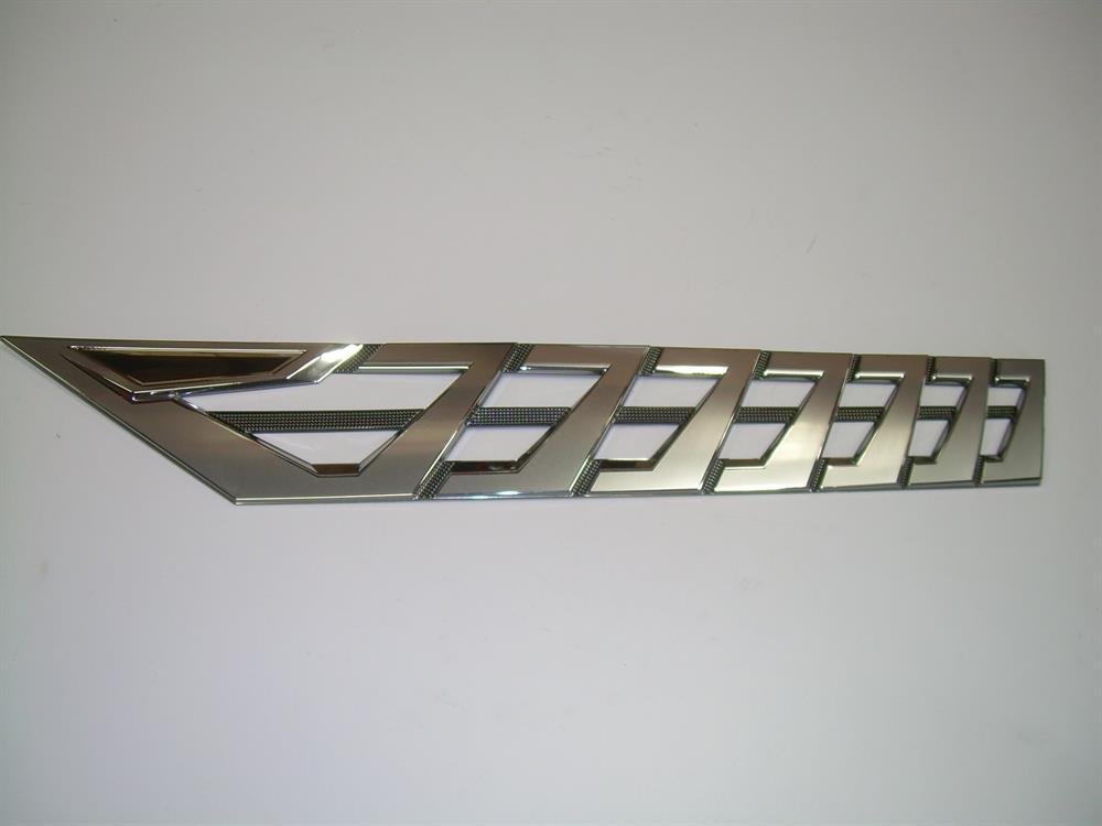 A Nautique DECAL VENT BRIGHT CHROMAX PORT 3.85 X 23.59 (170092) car fender trim, featuring multiple diagonal cutouts and a subtle Chromax port emblem, is displayed against a plain white background.