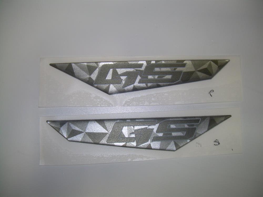 Two Nautique DECAL GS VENT INSERT SET .92 X 4.93 - 170151 stickers with a geometric GS pattern and 3D effect are shown side by side, ideal as Nautique vent insert accents.