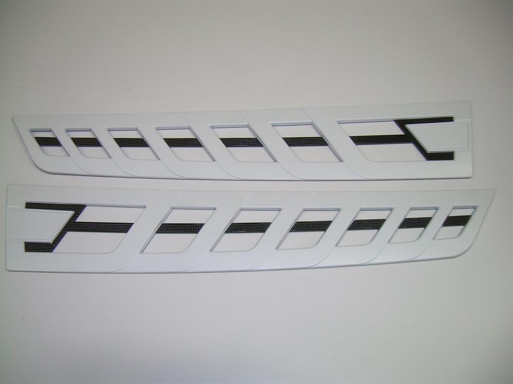 The Nautique DECAL TRANSOM VENT CHROMAX WHITE CHROME 4.3 X 23.32 - 170288 features two white trim pieces with black diagonal lines and angular cutouts, offering a sleek chromax white chrome finish for a modern look.