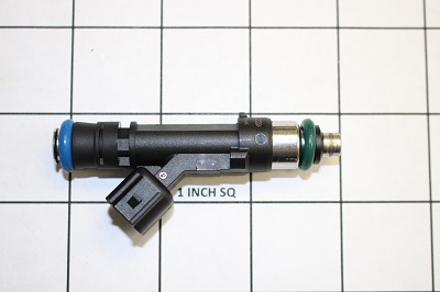 An Indmar INJECTOR FUEL SUPERCHARGED FORD - 592083, black with blue and green O-rings, is shown on a 1-inch grid to display the size of this Indmar component.