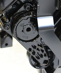 Close-up of an Indmar TENSIONER ASSEMBLY FORD 6.2 INSIDE PULLEY (597075M) with "Made in China" and other markings engraved on the black component, showing bolts and geometric cutouts.
