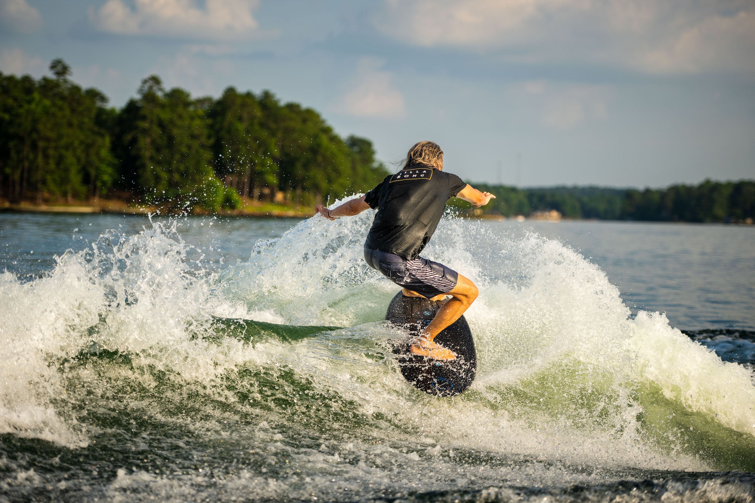 A man riding a wave on a Hyperlite 2023 Ranger Wakesurf Board with Durashell construction.