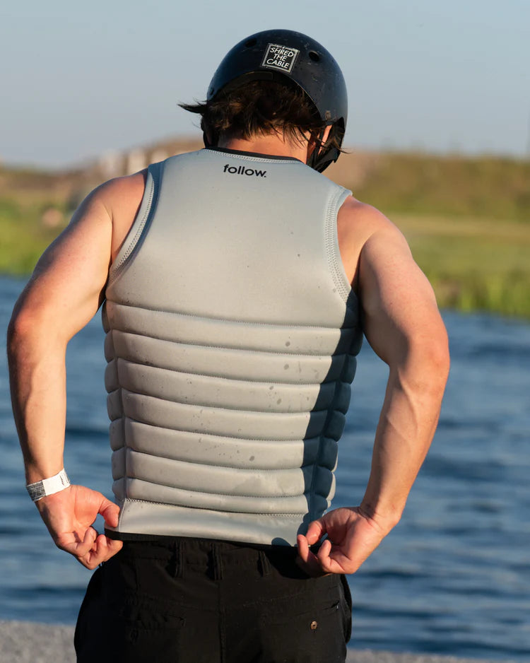 The back of a man wearing a Follow 2022 Primary Men's Jacket - Stone, providing maximum flex and impact protection.
