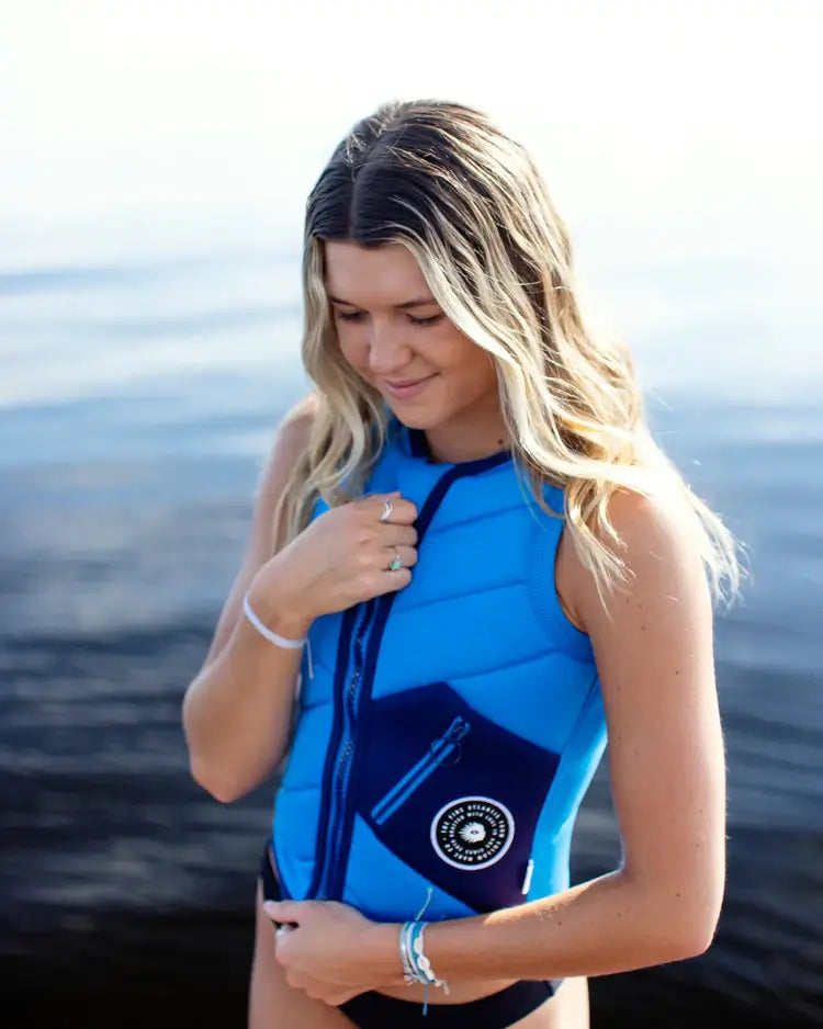 A woman wearing a Follow Atlantis Ladies Jacket - Royal Blue, riding blissfully.