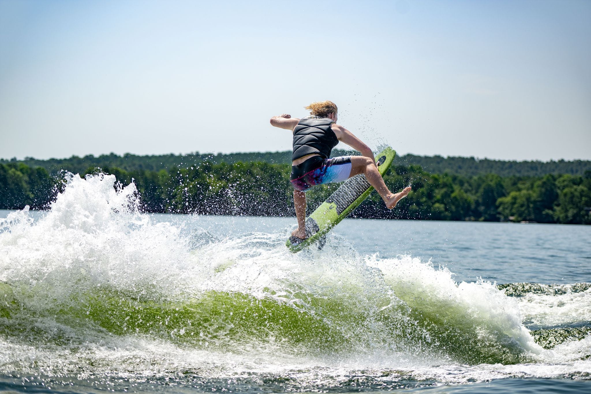 A man is riding a Hyperlite 2024 Varial ARC Wakesurf Board on a surfboard.