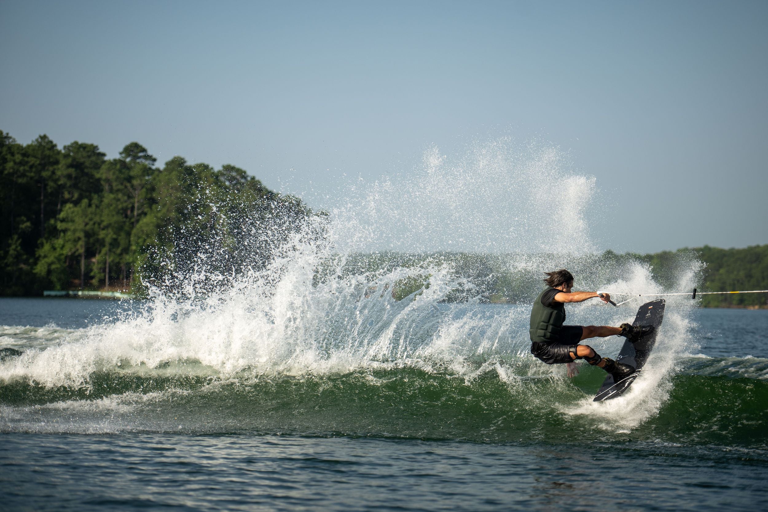 Josh Twelker is riding a wave on a Hyperlite 2023 Cryptic wakeboard.