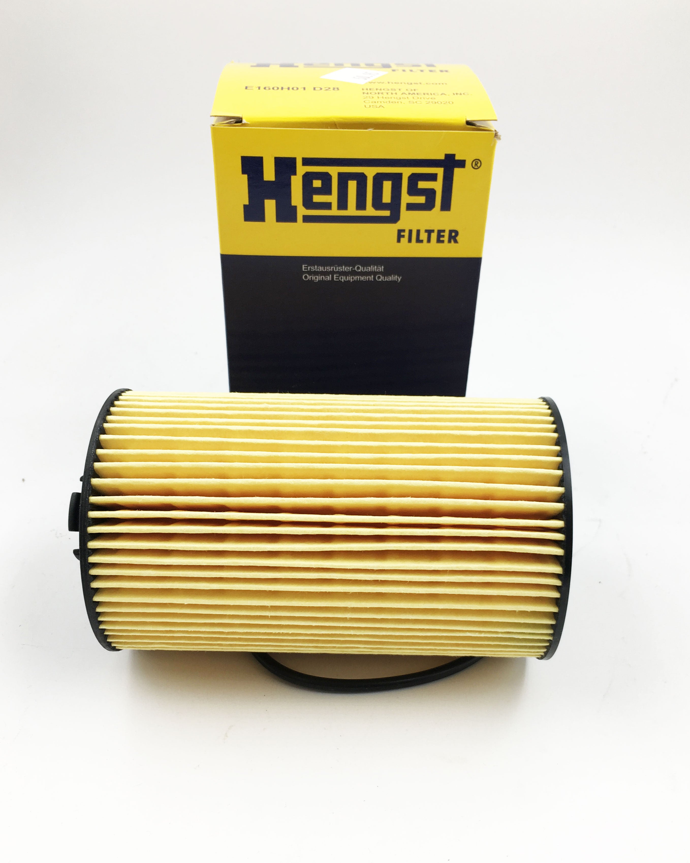A Malibu Hengst Oil Filter - E100160 sits horizontally in front of an upright yellow and black filter box. Both items are displayed on a white background.
