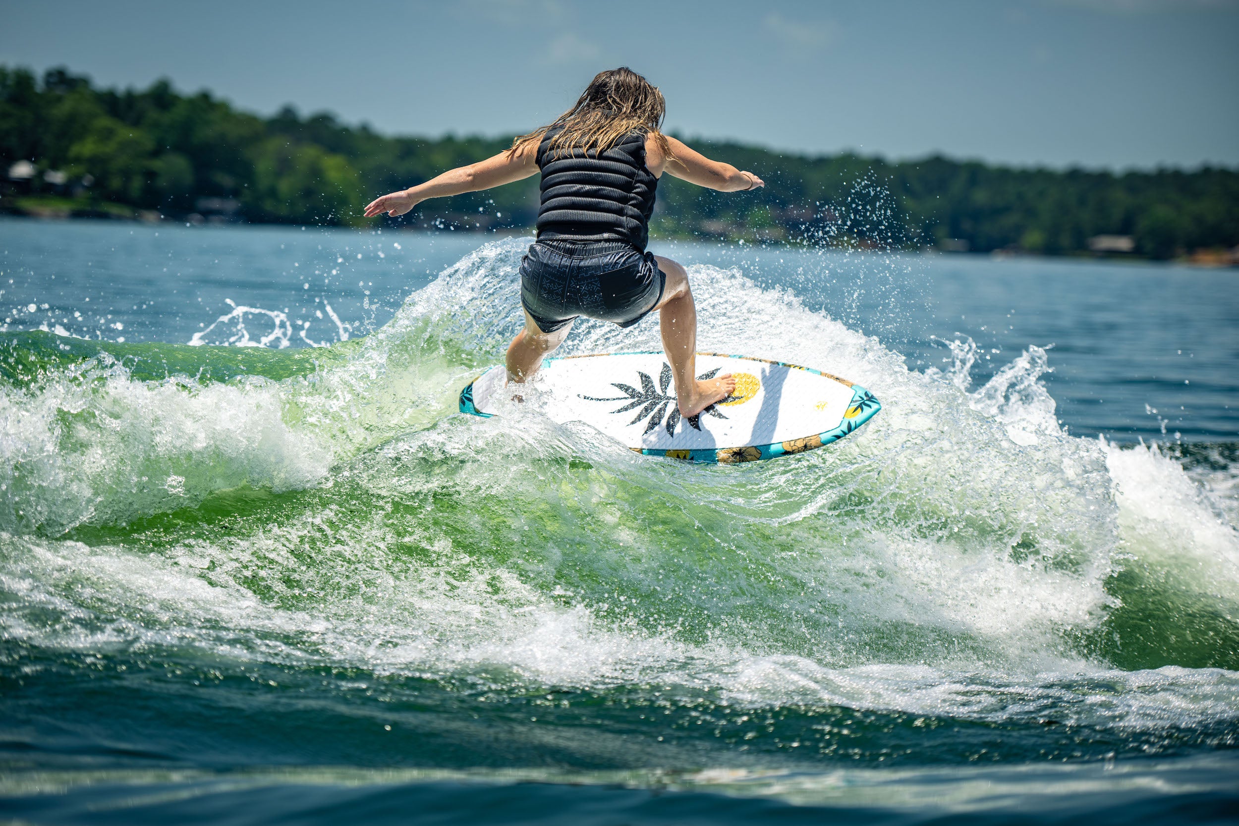 Hyperlite wakesurf enthusiast is seen riding a wave on a Hyperlite 2024 Good Daze Women's Wakesurf Board, catering to beginner to intermediate riders.