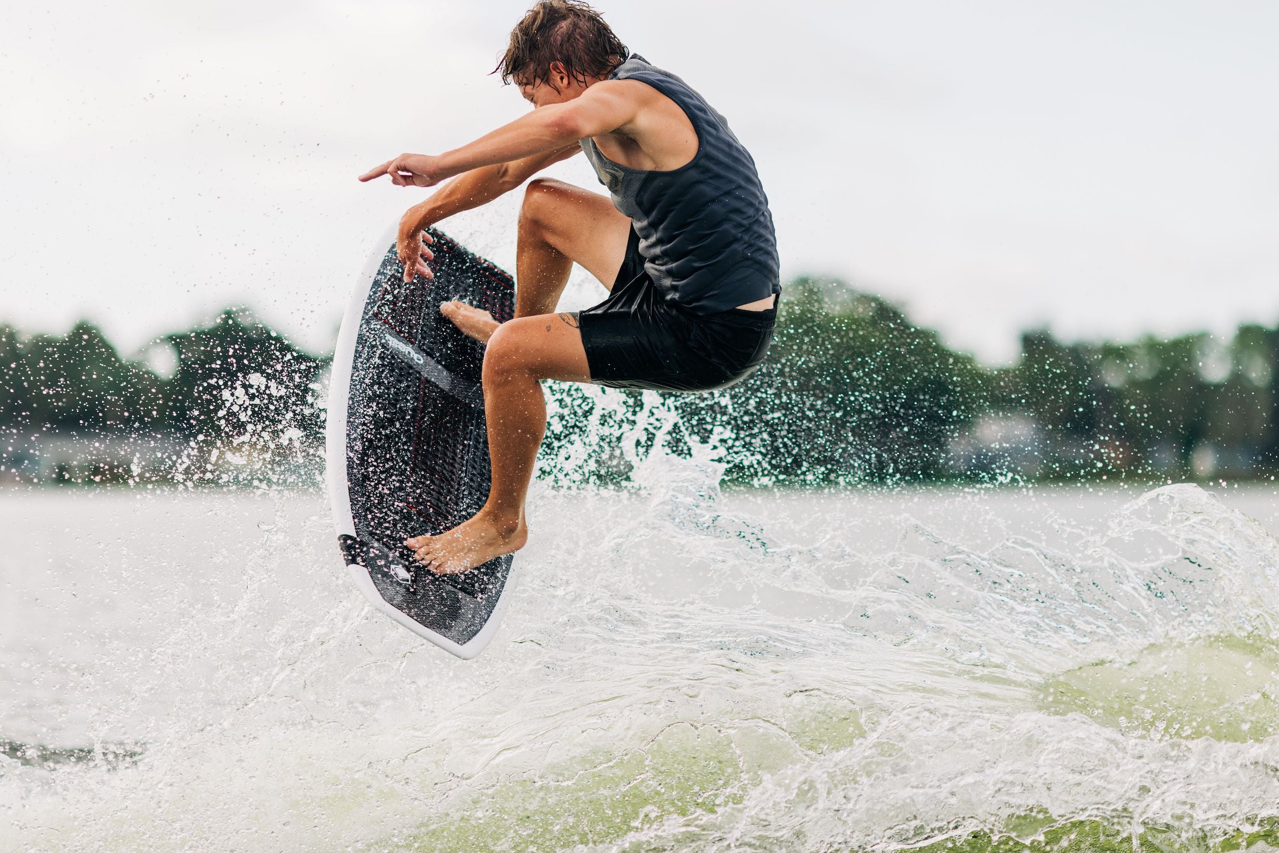 A man riding a Liquid Force 2024 Quest Wakesurf Board with lightning speed.