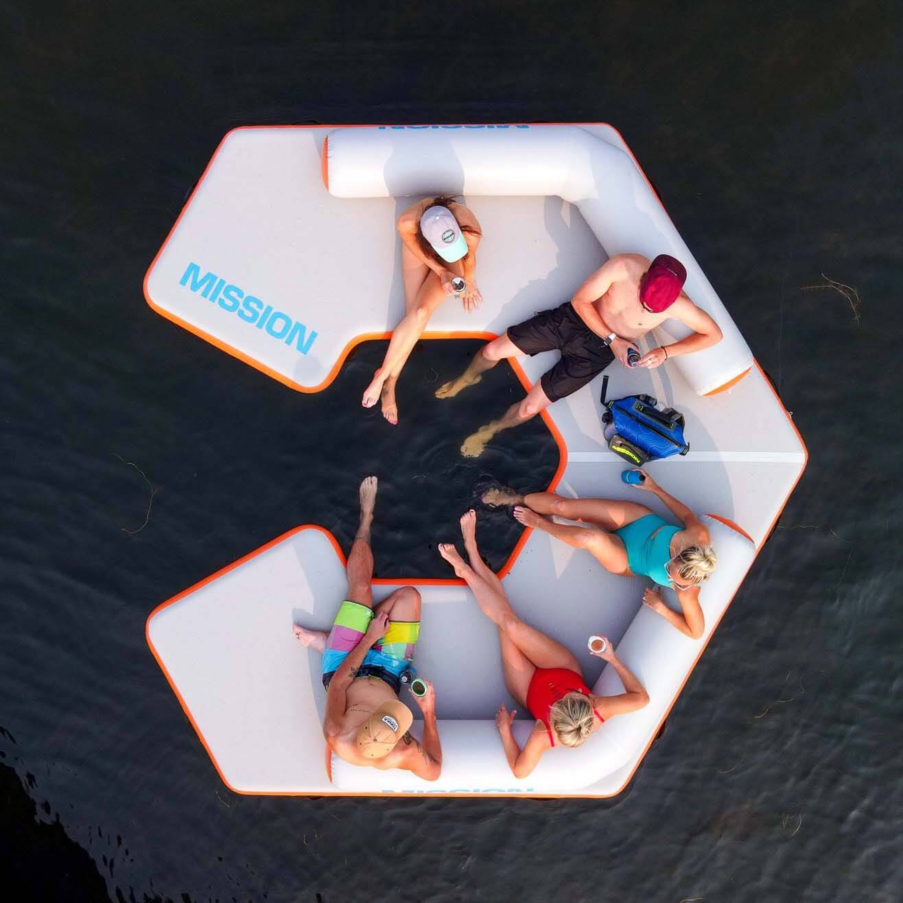 A group of people enjoying the MISSION Reef Hex 82 Mat by sitting on an inflatable floating lounger.