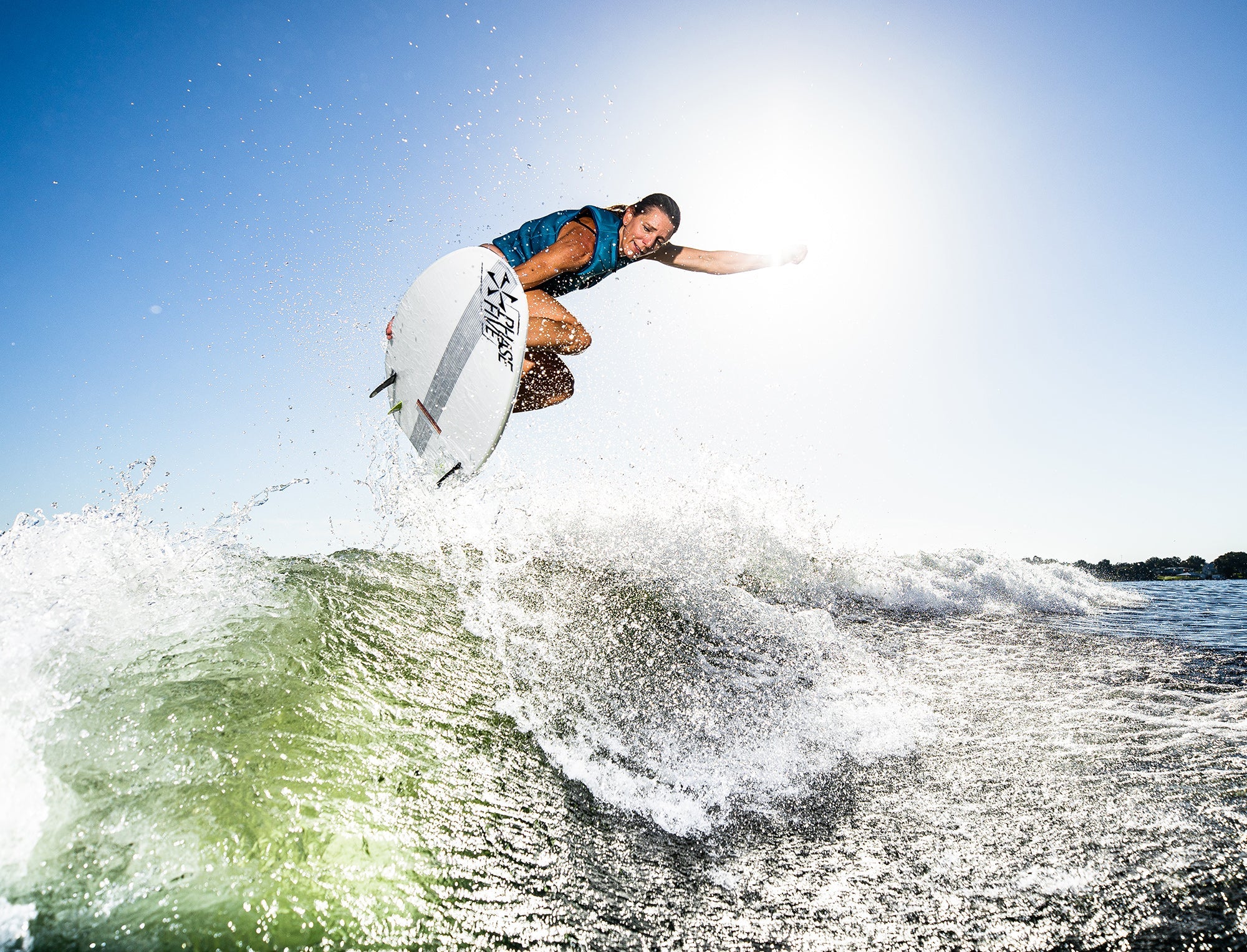 A man is riding a wave on a surfboard, harnessing the power of the Phase 5 2023 Swell Wakesurf Board.