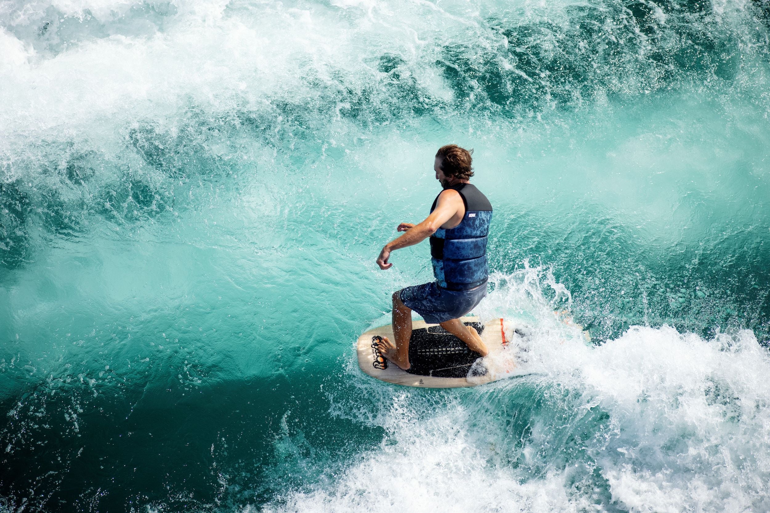 A man riding a wave on a Ronix 2024 Element Core Blunt Nose Skimmer for stability.