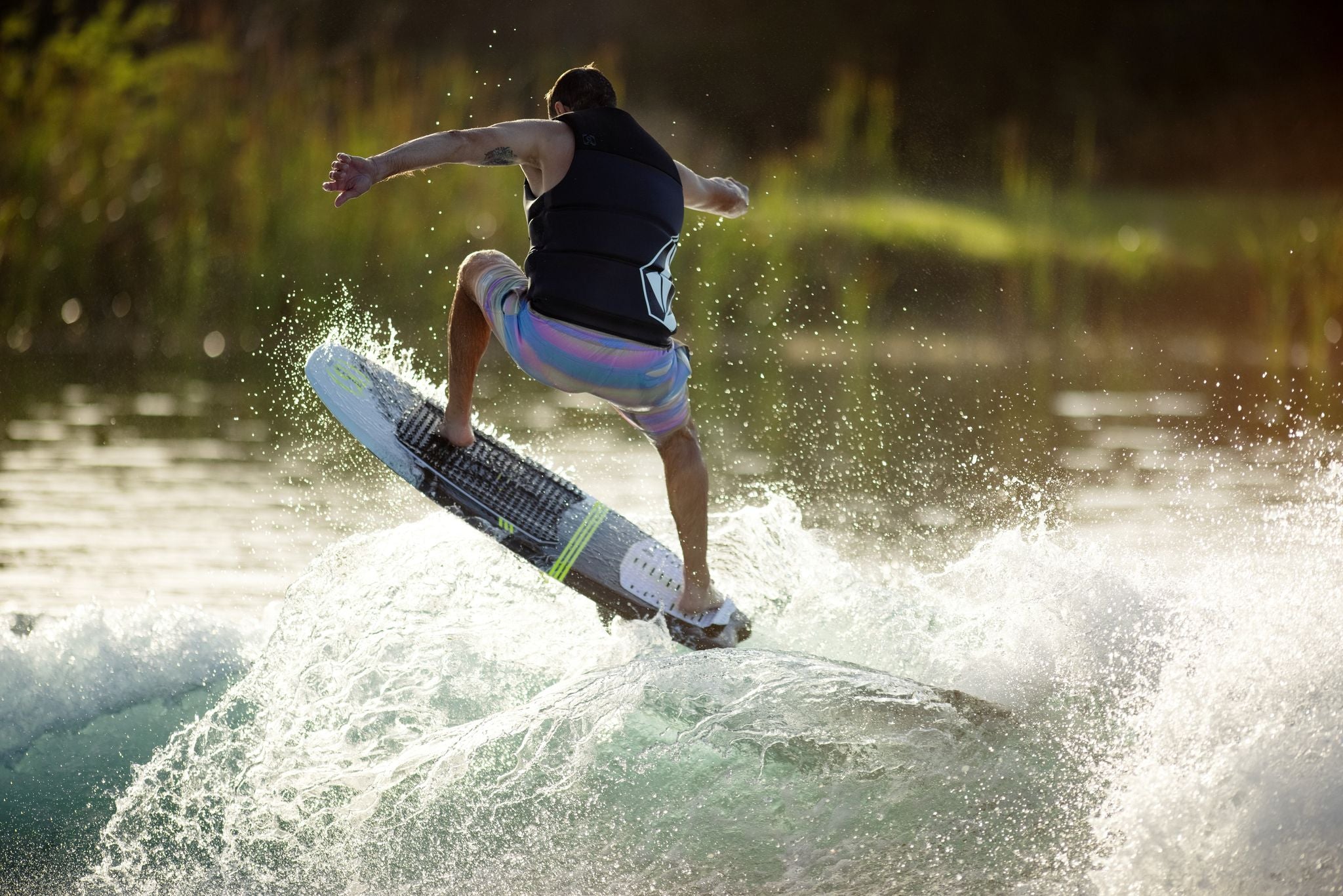 A man showcasing his freeride vibe while riding a wave on a Ronix 2023 Koal Surface Crossover Wakesurf Board.