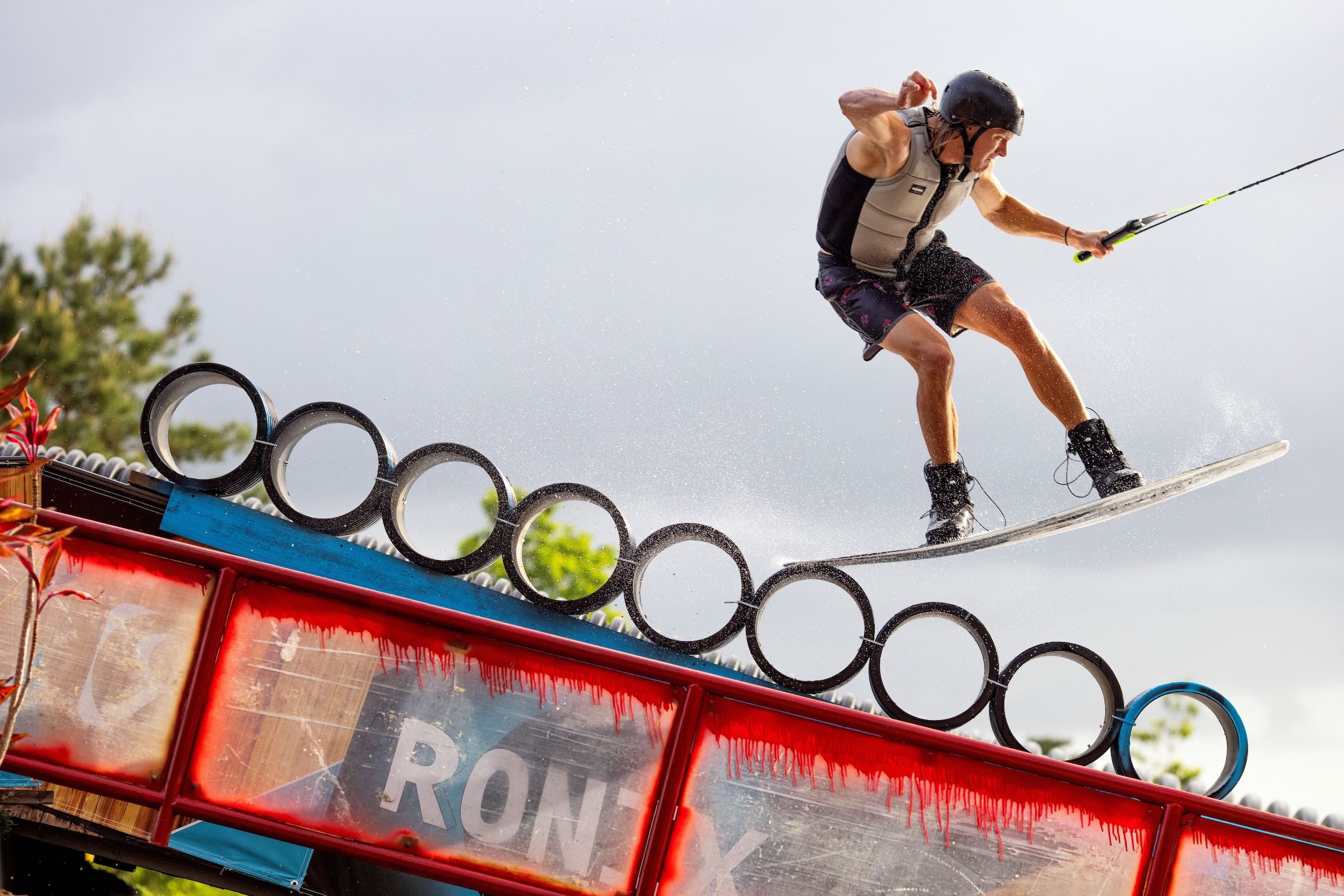 A man soaring through the air on a Ronix 2024 Supreme CE Approved Impact Vest.