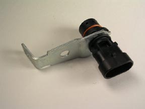 The Indmar SENSOR CRANK 5.7L - 556293 features a black sensor with an orange ring and metal bracket, designed for 5.7L engines by Indmar, displayed on a plain light surface.