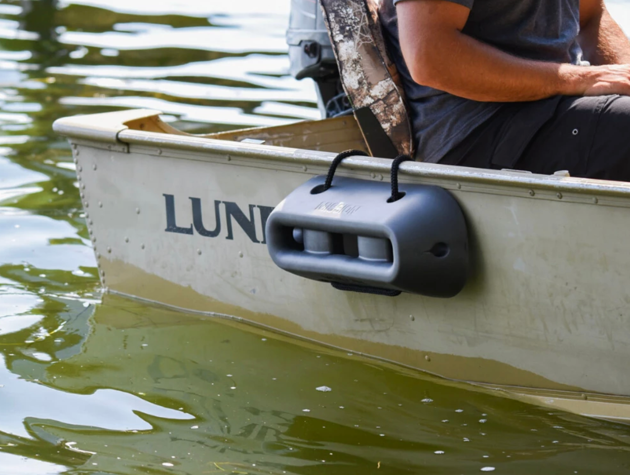 A man is sitting in the back of a boat with a MISSION Icon Boat Fender, providing protection to the vessel.