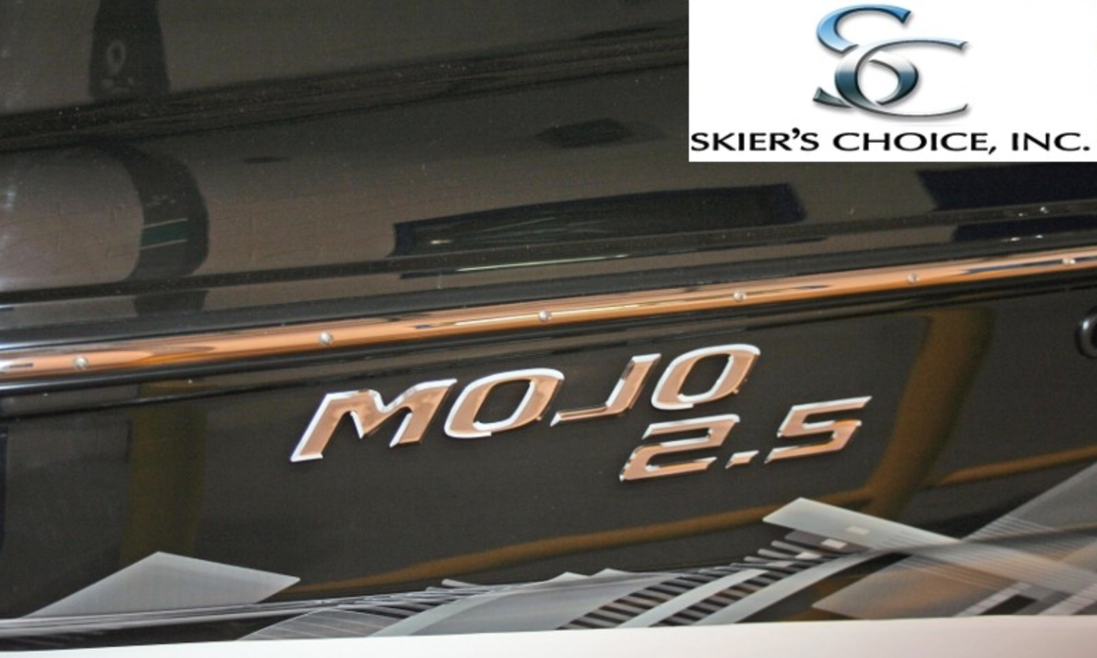 Close-up of the Moomba Mojo 2.5 Chrome Decal (114213) on a black surface, featuring chrome "MOJO 2.5" letters and a Skiers Choice, Inc. logo with a stylized SC in the top right corner. Brand: Moomba.