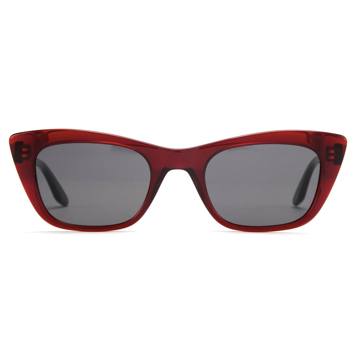 The Otis Suki - Cherry/Grey by Otis is shown front-facing against a white background. These glossy red cat-eye sunglasses have mineral glass lenses, dark UV protection, and bold, slightly pointed edges in a classic style.