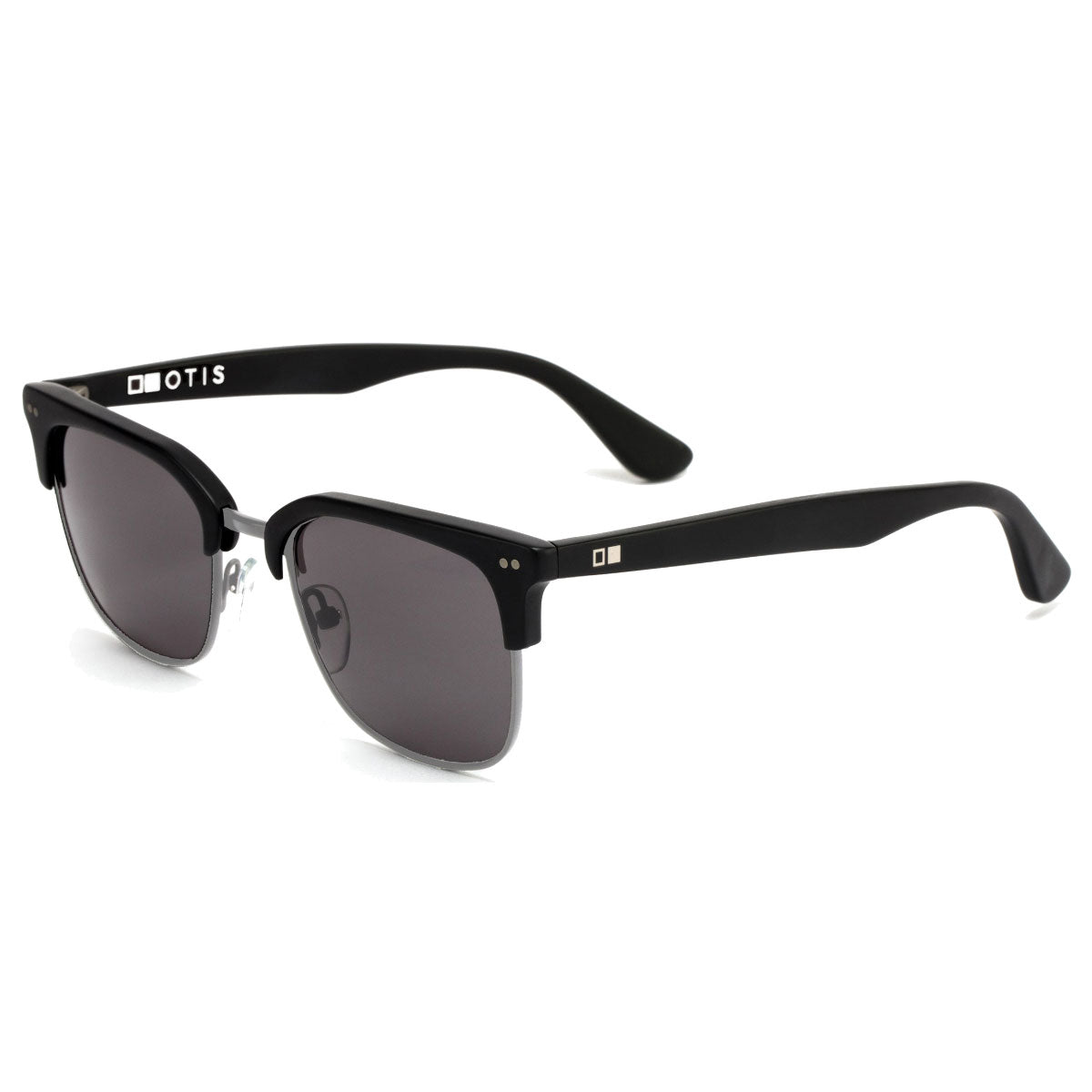 The Otis 100 Club in Matte Black/Grey Polar features black semi-rimless handmade acetate frames, dark mineral glass lenses, silver temple accents, and white OTIS branding on the left arm, offering a classic, retro-inspired look.