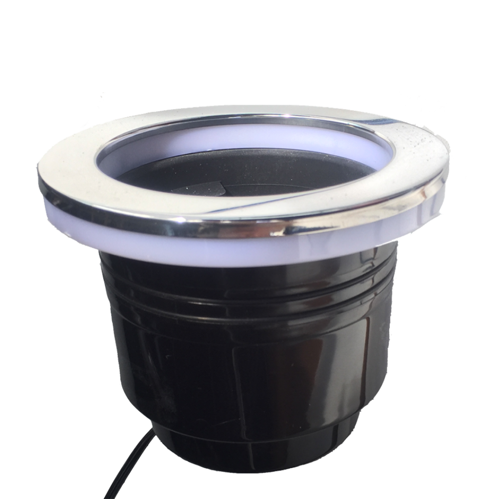 The Nautique LED Cup Holder- White (160384) by Nautique is a black, cylindrical pool light with a silver rim and white LED ring, ideal for boat accessories or a stylish Nautique-inspired cupholder, shown on a plain white background.