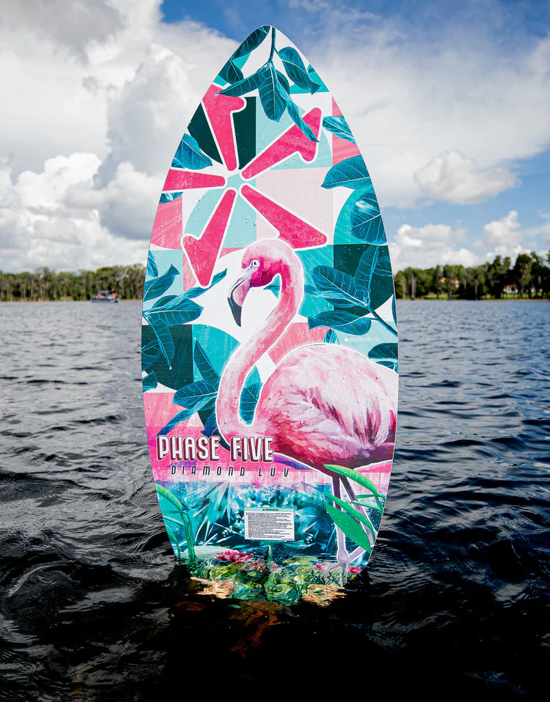 A Phase 5 2024 Diamond Luv Wakesurf Board, featuring a flamingo on it, glides through the water.