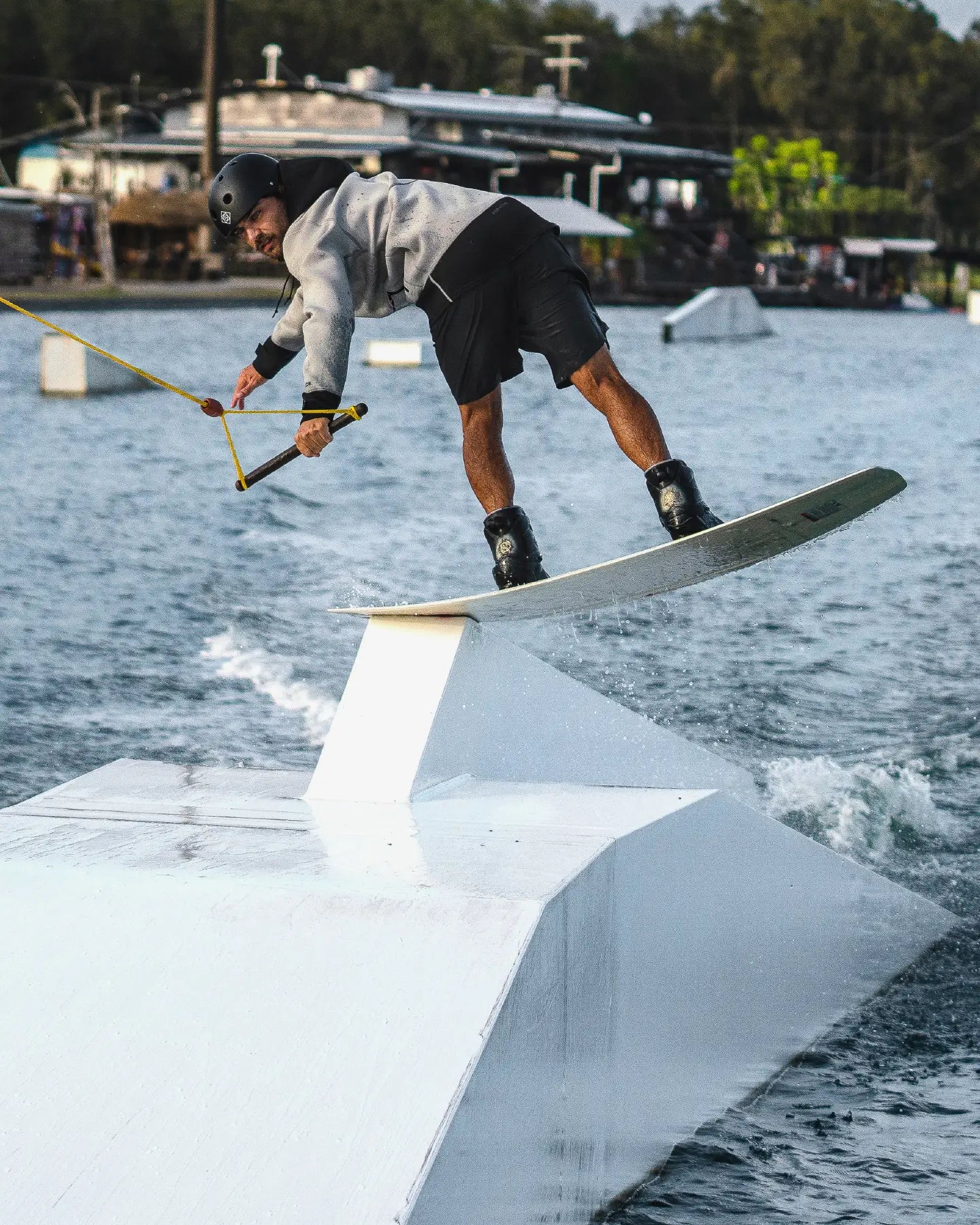 Alex Aulbach does a board slide on his wakeboard wearing the Follow Pro Neo Jacket in Cream