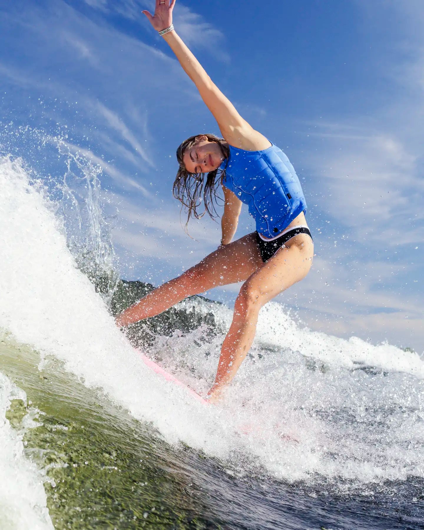 Cassidy Gale slashes the wake on her wakesurf board wearing the Follow Total Womens Impact Vest - Blue