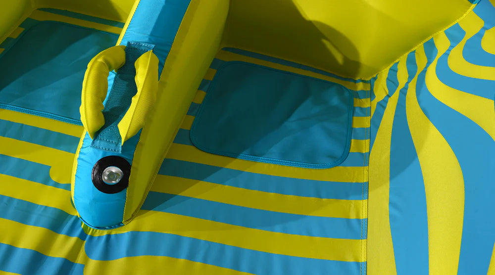 Close-up of the HO Sports HO 3G Tube 2026 featuring blue and yellow wavy stripes, stitched details, and a side handle. Sunlight highlights its swept-wing design.