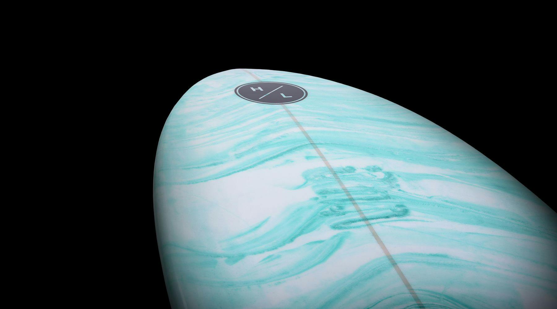 The image showcases a top view of the Hyperlite 2025 Frother 2.0 Wakesurf Board, featuring a light turquoise marble design against a black background, emphasizing its sleek epoxy construction.