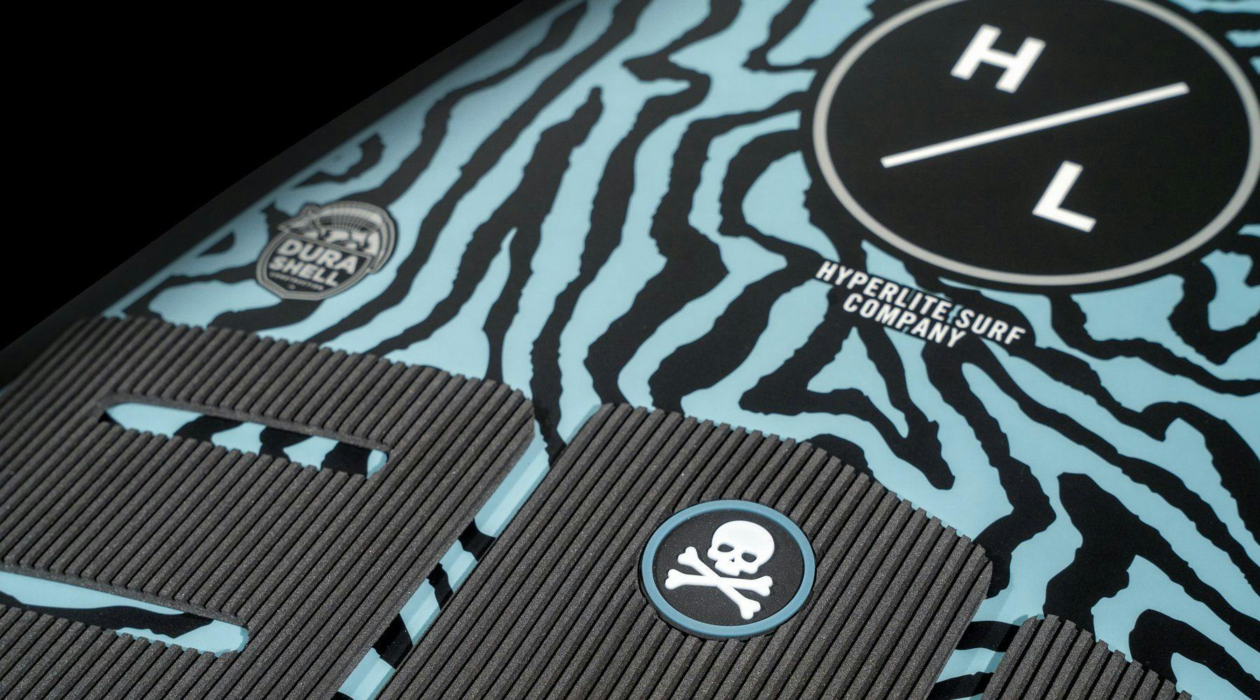 Close-up of the Hyperlite 2025 Ranger Wakesurf Board, showcasing its blue and black zebra stripes with a prominent Hyperlite logo, DuraShell Construction for unparalleled durability, and a skull and crossbones design.