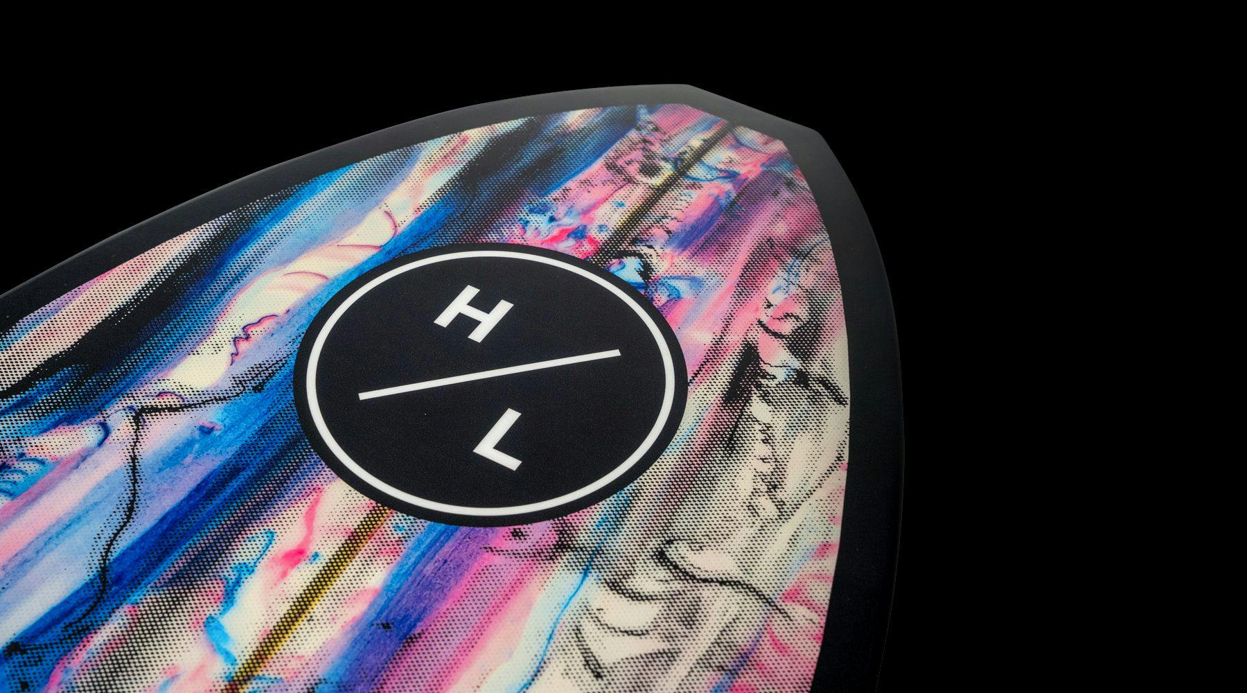 The Hyperlite 2025 Ranger Wakesurf Board showcases a colorful marbled design in pink, blue, and purple with black edges on the tip. Constructed using durable DuraShell Construction, it features the Hyperlite logo with the letters H and L separated by a diagonal line within a black circle.