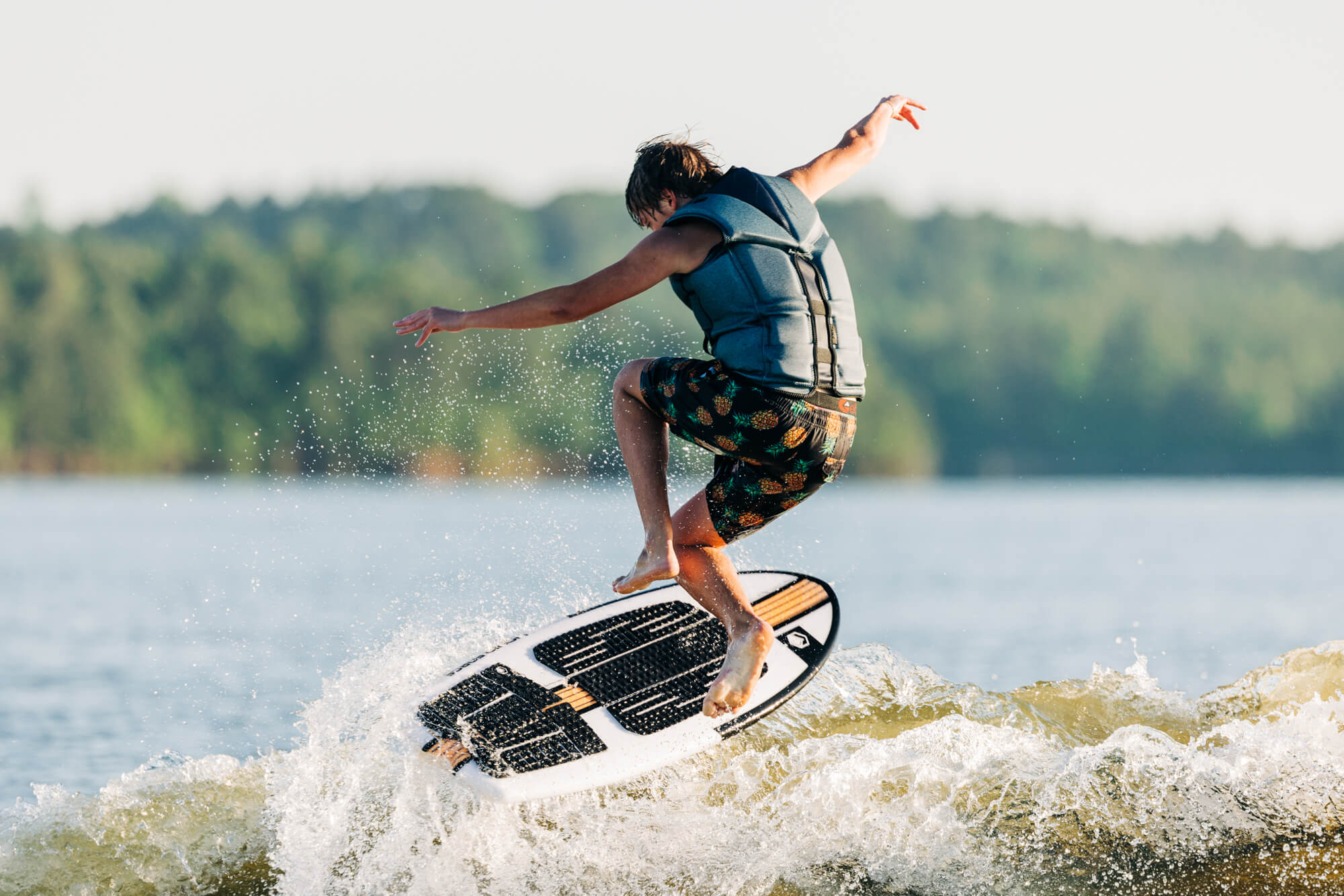 A man on a surfboard riding a wave with the Liquid Force 2024 Quattro Wakesurf Board (Pre-Order), a surf-style shape.